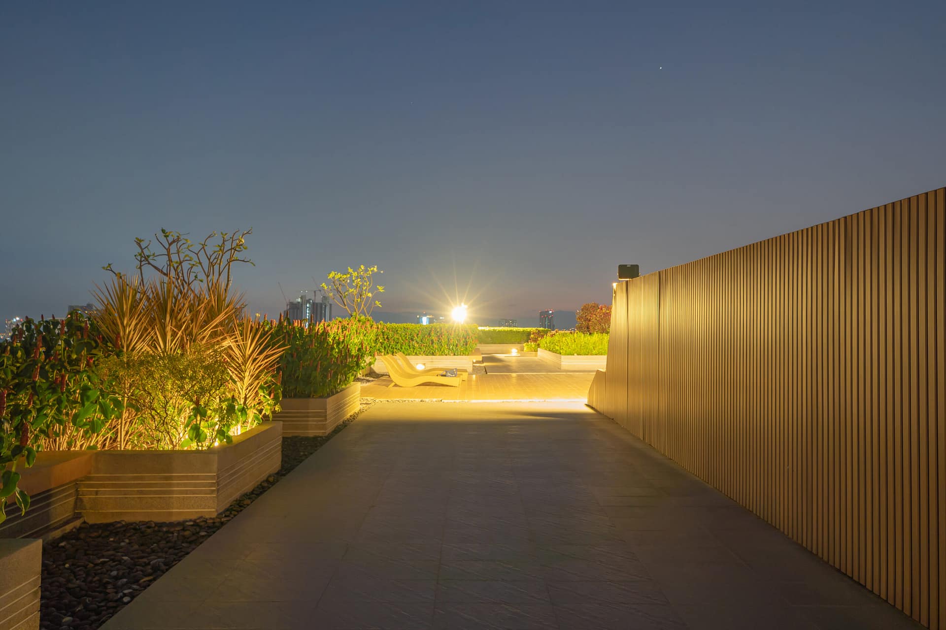 Sky garden on private rooftop of condominium or hotel, high rise architecture building with tree, grass field, and blue sky.