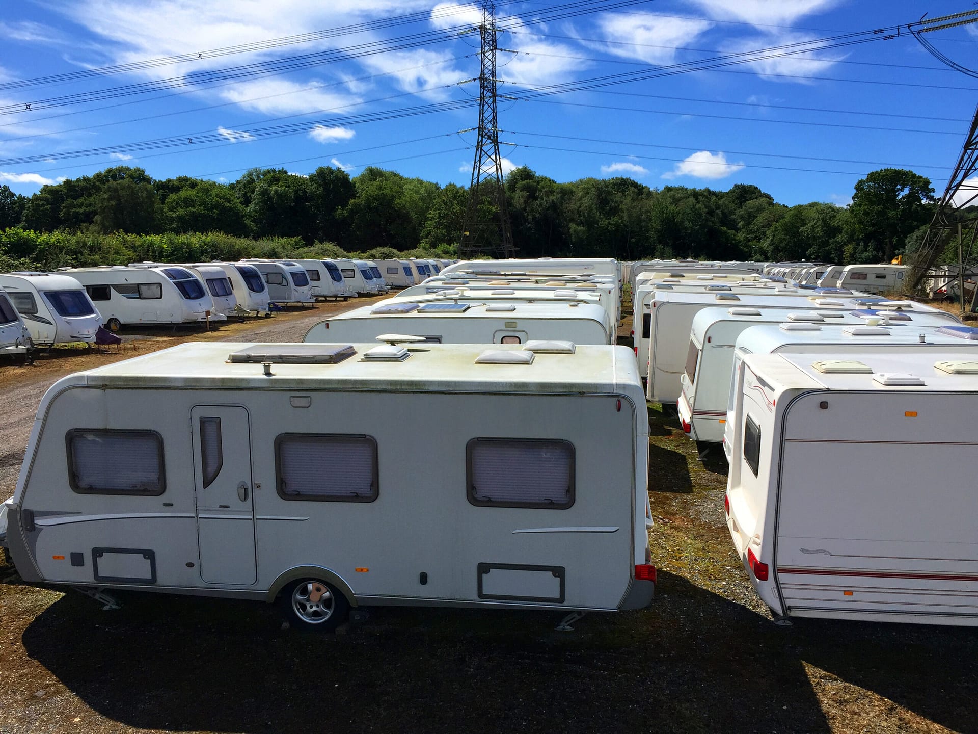 Caravans stored in rows on a sunny day.